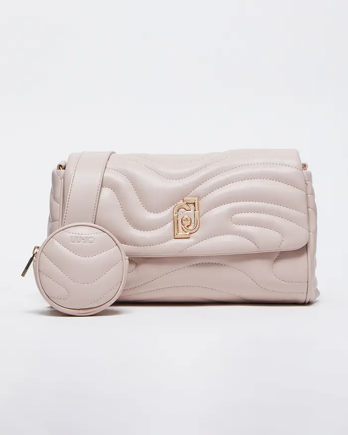 Borsa color cipria in similpelle trapunatata a onde con patta logata e tracolla in gros-grain con charm portamonete