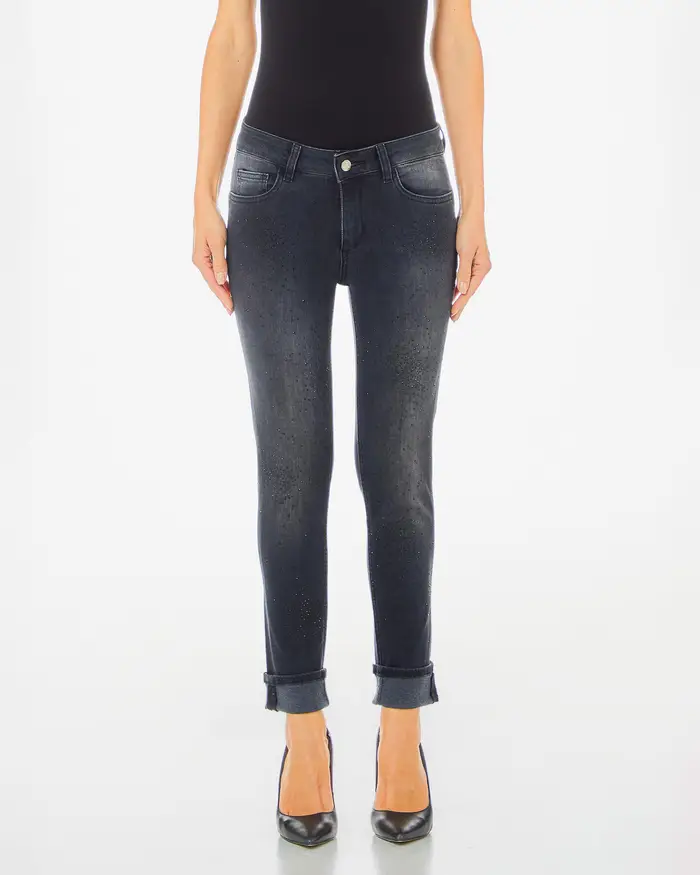 Jeans skinny nero lavato a vita media con strass in tono applicati all over sul davanti