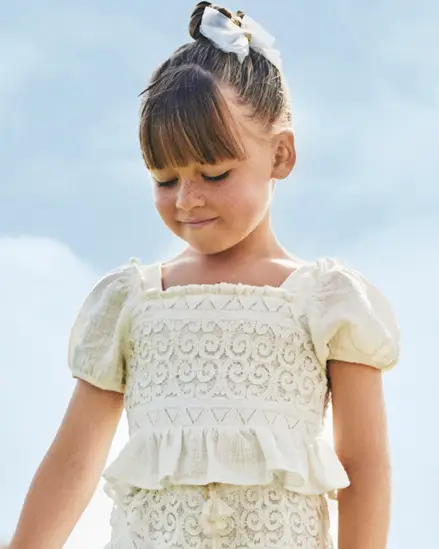 Camicietta bianca cropped in crochet con maniche a sbuffo